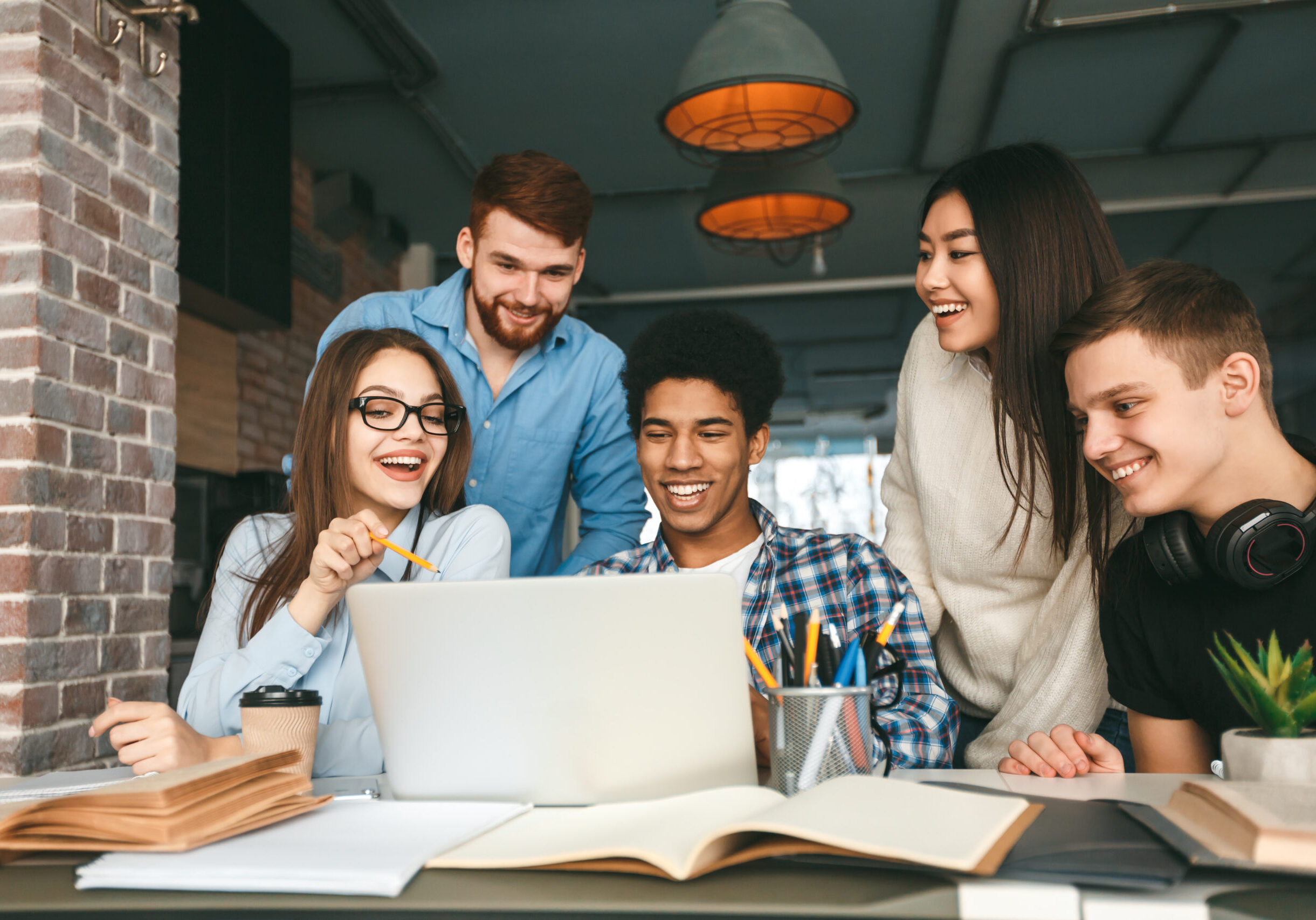 Studying together. College students preparing for classes in library Studying together. College students preparing for classes in library, using laptop