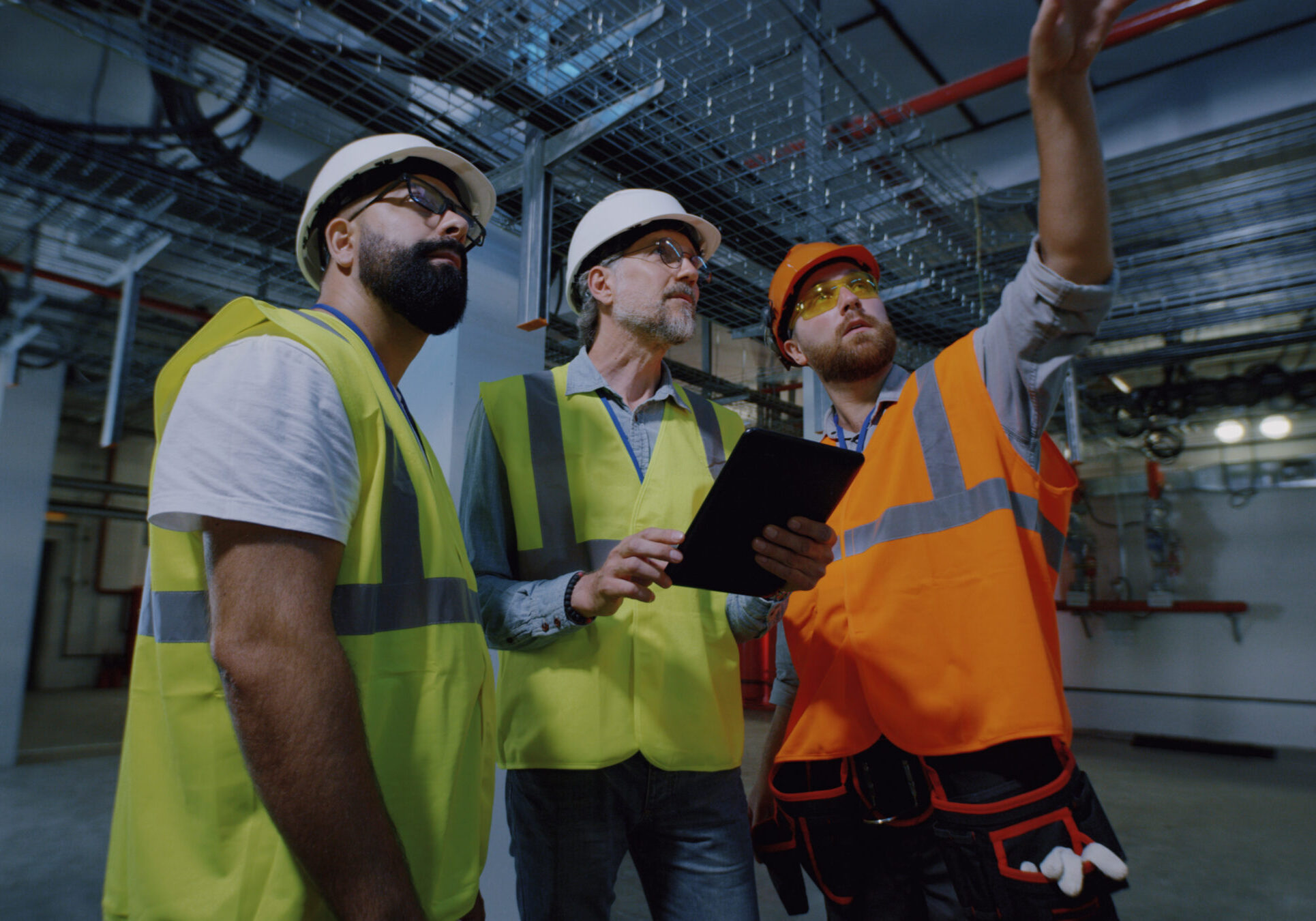 Engineers inspecting dark workshop of power plant Tracking shot of foreman talking and demonstrating dark workshop to male inspectors while working on wind power station